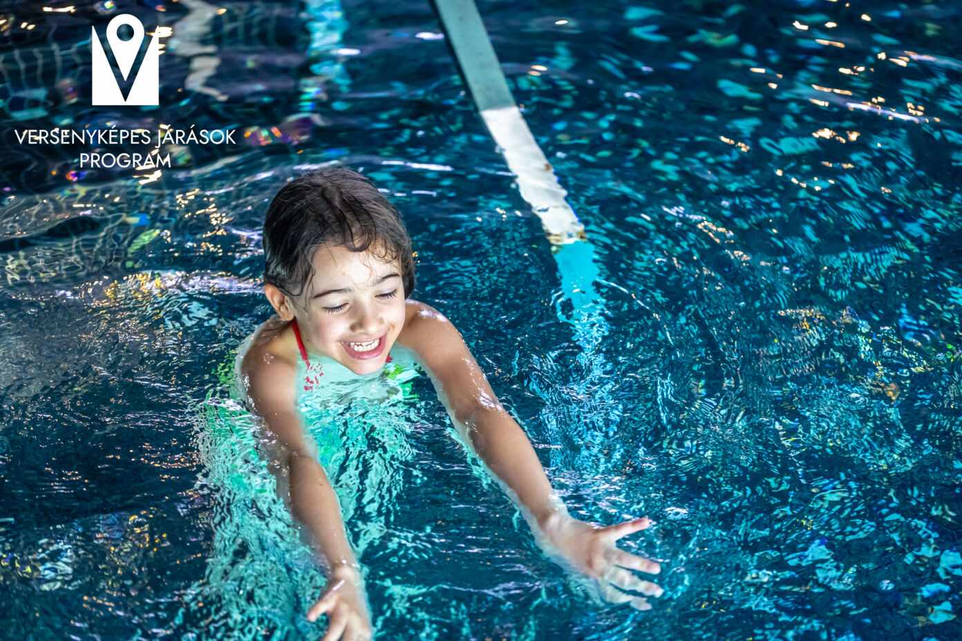 A young teenager girl in a swimsuit, swimming in a blue pool.