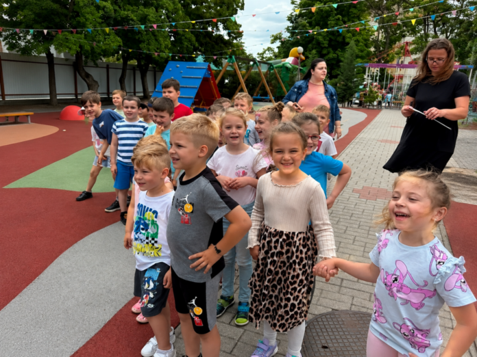 Mosolygó gyermekek a kiskőrösi Harangvirág Óvoda gyermeknapi rendezvényén, ahol játékokkal, buborékshow-val és színes programokkal ünnepeltek.